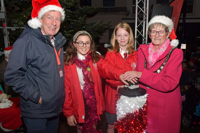 Clinton Rogers and Mayor Janet Lloyd pose with Reece and Izzy from St Johns Primary School. They hold their hands over the big red button to switch on the lights.